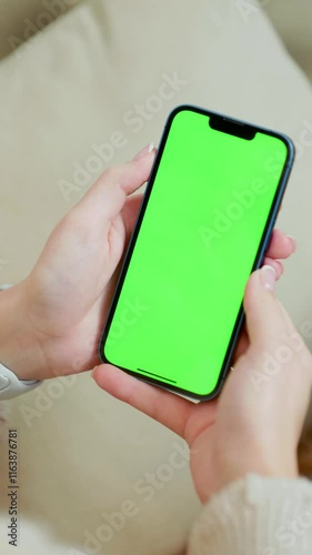 Mobile Phone With Green Mock Up Screen In Female Hands Close Up. Vertical Video