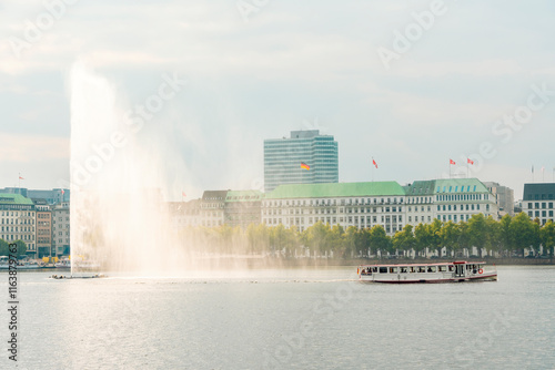 Binnenalster with the Alster fountain and a ferry boat in the afternoon in Hamburg, Germany photo