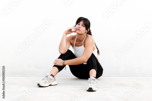 Beautiful woman sitting against white background photo