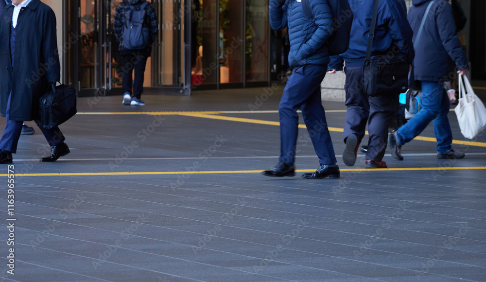 Obraz premium 冬の都市の繁華街で歩くビジネスマンと人々の姿