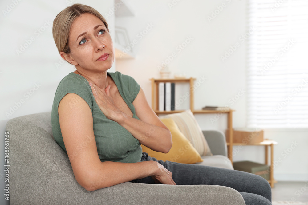 Menopause. Woman suffering from hot flash on sofa indoors Menopause. Woman suffering from hot flash on sofa indoors