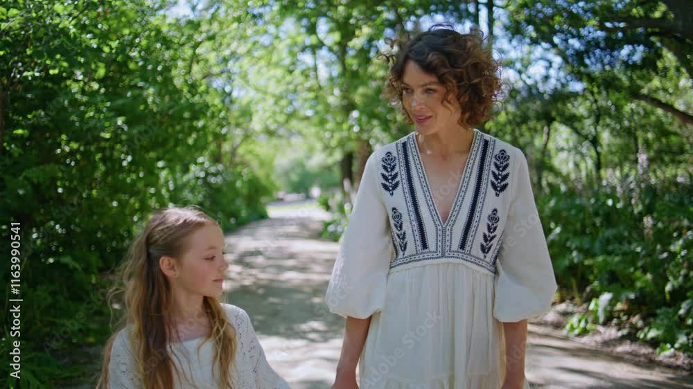 Mother daughter strolling park at sunny day closeup. Relaxed woman girl walking Mother daughter strolling park at sunny day closeup. Relaxed woman girl walking