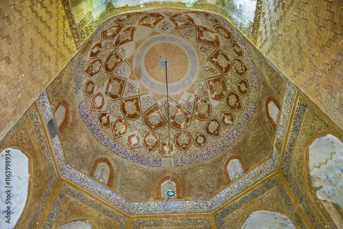 Interior view of medieval mausoleum with classical Persian paintings interspersed with religious inscriptions in Farsi. Building is called Green Dome, located in the Gonbad Garden, Qom, Iran photo