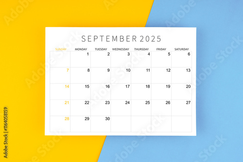 September 2025 calendar page on yellow and blue background. photo