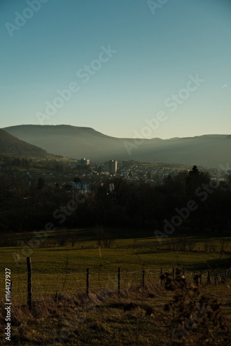 misty sunset over city with mountains