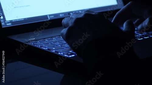 person typing on a laptop in a dark environment