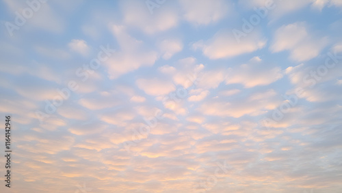 A serene sky filled with soft, colorful clouds reflecting the beauty of nature. photo