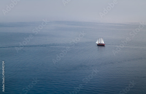 Sailboat on tranquil open sea minimal maritime horizon. Solitary sailing vessel symbolizing adventure, freedom, and serenity.