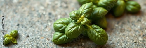 Fresh basil leaves arranged on a textured surface ready for culinary use in cooking or garnishing dishes photo