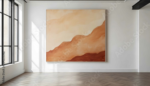 Desertinspired abstract painting with sandy and terracotta hues on a white wall in an empty room photo