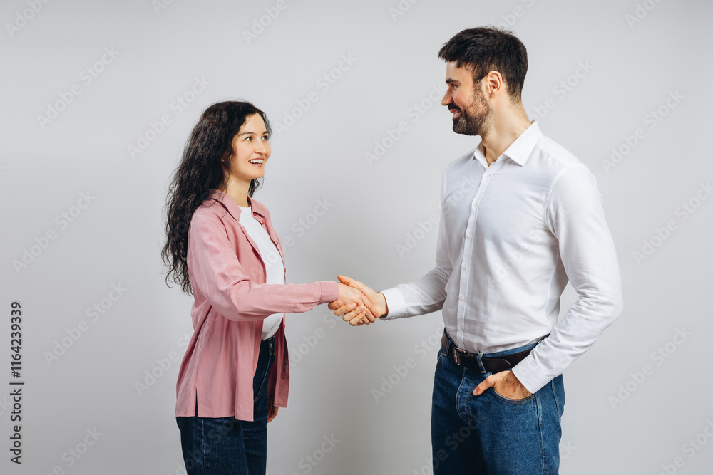 Business partners shaking hands, smiling, and reaching an agreement Business partners shaking hands, smiling, and reaching an agreement
