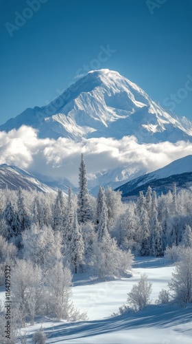 Snow-covered mountain peak rises majestically above the clouds in bright dayl...