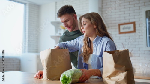 Couple putting shoppings kitchen table arrived from grocery store home closeup