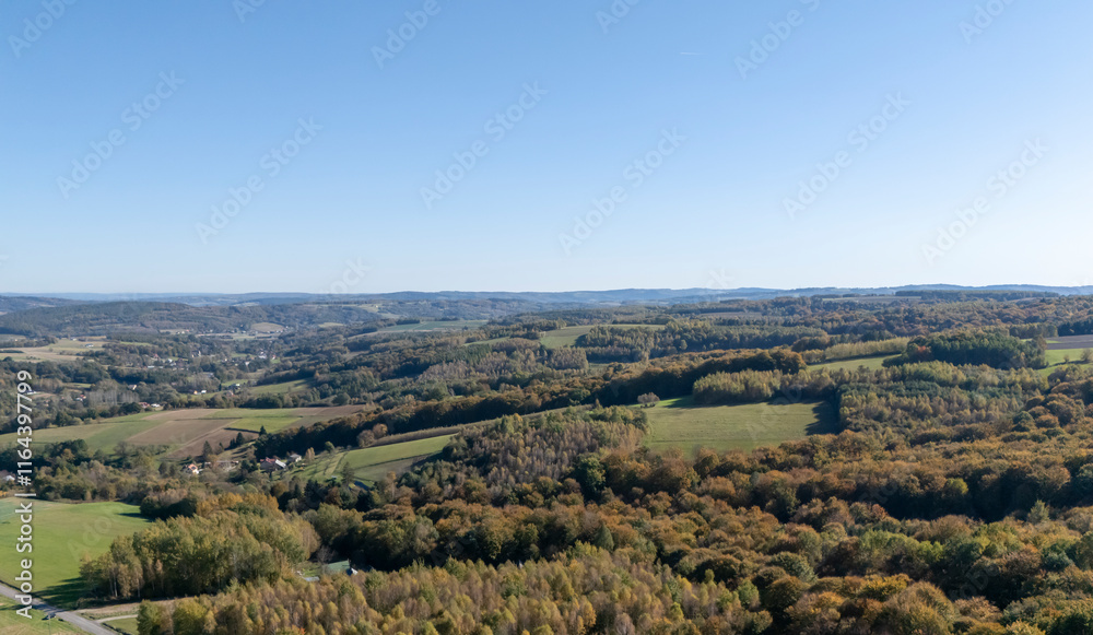 Aerial view of a vast landscape showcasing an expanse of colorful autumn foliage under a clear blue sky. Aerial view of a vast landscape showcasing an expanse of colorful autumn foliage under a clear blue sky.
