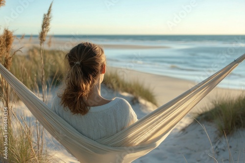 Relaxing on a hammock by the tranquil beach at midday under a clear blue sky