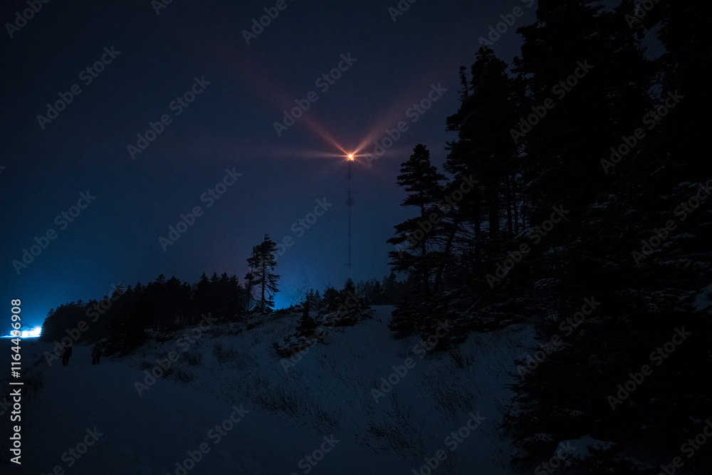 Lighthouse Lit Up in Orange Color in the Forest at Night in Winter at Night in Anticosti Island, Quebec