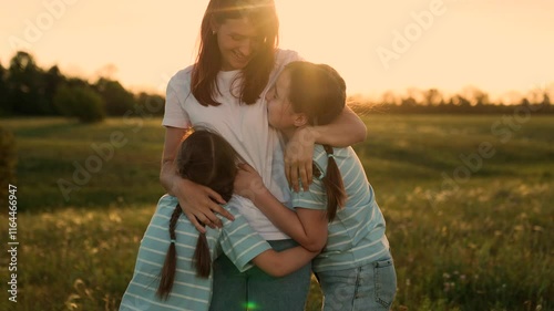 Family reunion field, Children running mom, Outdoor fun during sunset, Happy family moments, Summer evening joy, Kid mom embrace, Warm sunset nature, Family bonding time, Scenic outdoor playtime.