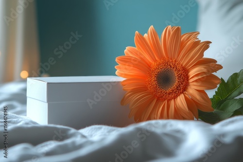 Delivered gift box resting on soft fabric with colorful flowers nearby in a b...