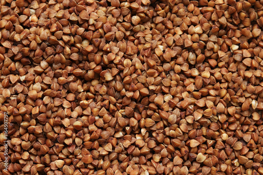 Buckwheat groats, top view. Raw large buckwheat grains, uncooked porridge. Buckwheat background. Raw buckwheat texture background, brown grains pattern Buckwheat groats, top view. Raw large buckwheat grains, uncooked porridge. Buckwheat background. Raw buckwheat texture background, brown grains pattern