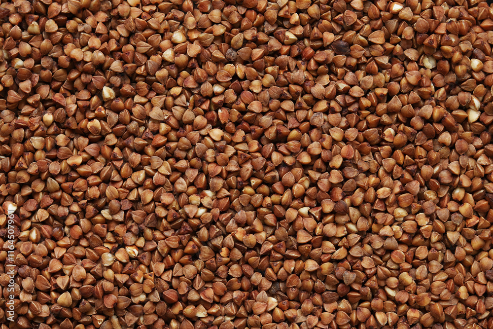 Buckwheat groats, top view. Raw large buckwheat grains, uncooked porridge. Buckwheat background. Raw buckwheat texture background, brown grains pattern Buckwheat groats, top view. Raw large buckwheat grains, uncooked porridge. Buckwheat background. Raw buckwheat texture background, brown grains pattern