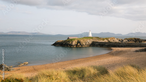 Calm beach in Anglesey with snowdonia mountains in the background