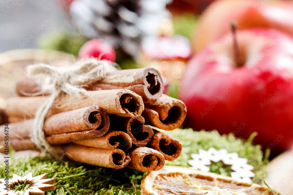 Cinnamon sticks on green moss background.