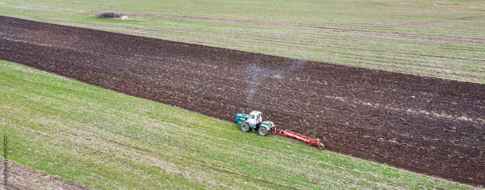 The tractor prepares the ground for sowing and cultivation. Agriculture and agronomy concept.