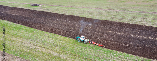 Obraz na płótnie The tractor prepares the ground for sowing and cultivation. Agriculture and agronomy concept. w salonie