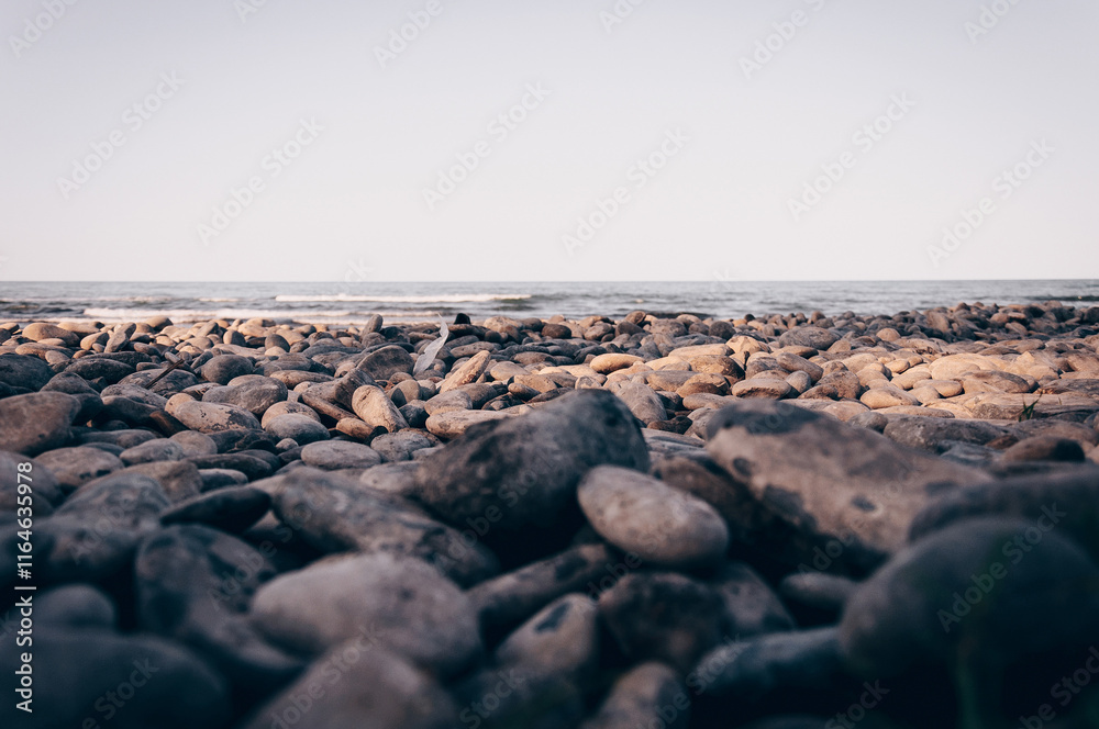 Pebbles beach with sea in background, foggy summer day Pebbles beach with sea in background, foggy summer day