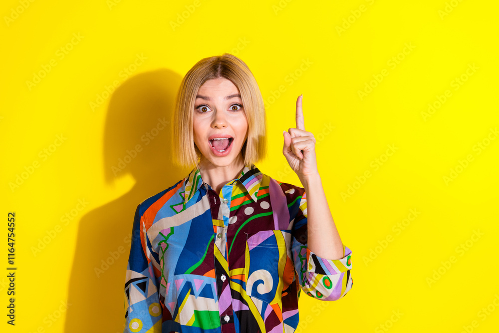 Photo portrait of pretty young girl excited point up empty space wear trendy colorful outfit isolated on yellow color background Photo portrait of pretty young girl excited point up empty space wear trendy colorful outfit isolated on yellow color background