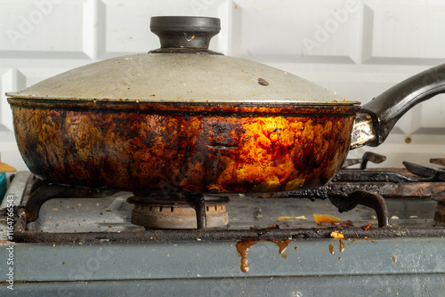a dirty, greasy pan on the stove in soot