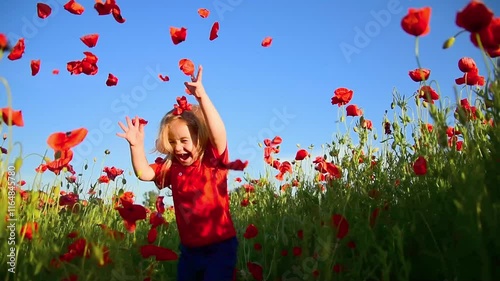 Happy kid enjoying spring. Child baby in spring meadow of blossom poppy flowers. Little kid and summer play nature. Baby throwing poppy petals. Spring vibes. Emotional kid portrait.