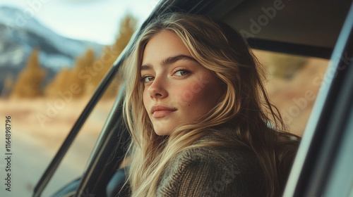 Young woman enjoying nature while sitting in a vehicle by a scenic mountain road