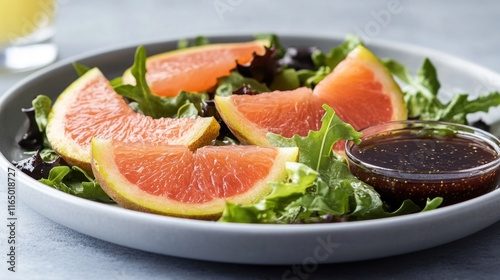 Fresh Salad with Grapefruit Slices and Dressing on a Gray Plate