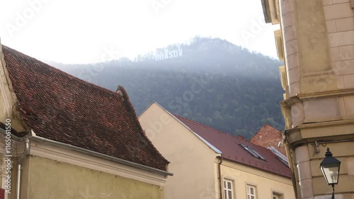 Old Town Residential Buildings In Brasov Romania With Brasov Sign On Top Of Mountain In Background