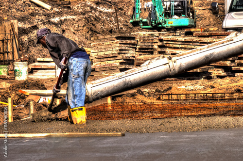  concrete Floor being poured and smoothed by construction worker