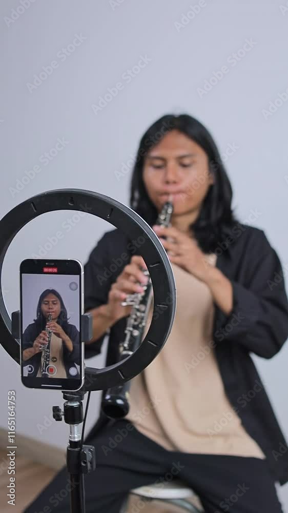 Asian Man Music Influencer Record Video Playing Oboe Using Phone For His Video Content On Social Media Asian Man Music Influencer Record Video Playing Oboe Using Phone For His Video Content On Social Media