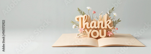 Thank you sign emerging from an open book with floral bouquet