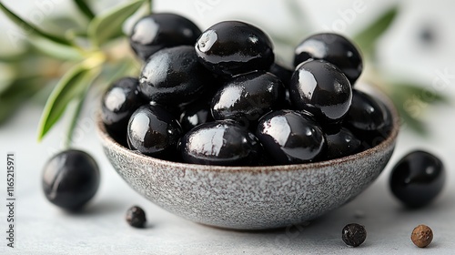 Bowl of shiny black olives with rosemary.