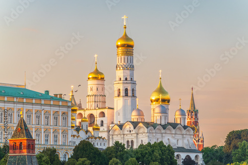 Ivan the Great Bell Tower, with Assumption Belfry on the right in Moscow Kremlin. Blue sky background with sunbeams