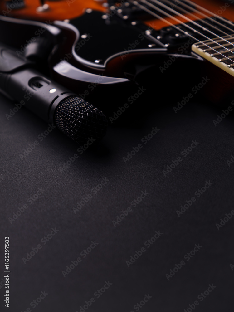 Obraz premium Microphone and electric guitar on a dark background.