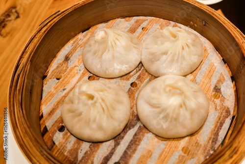 close up of shanghai Chinese steamed soup meat dumpling dim sum in a bamboo steamer  photo