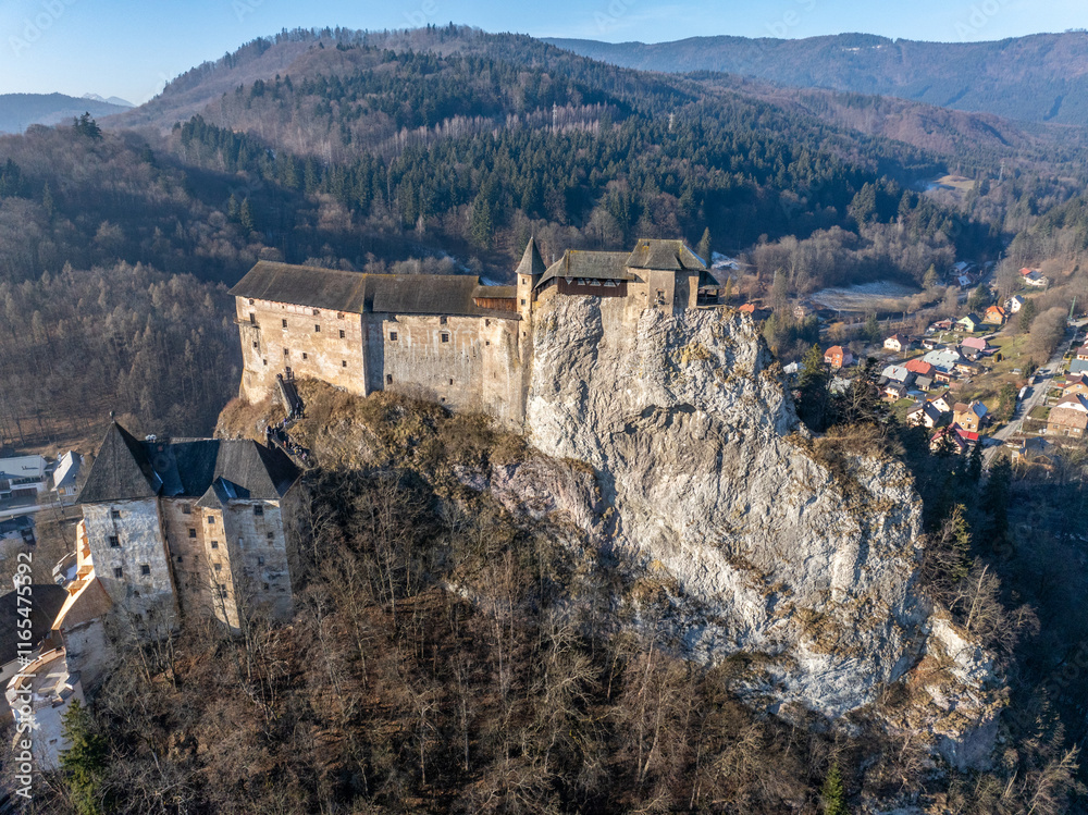 Obraz premium Aerial view of the Orava castle at winter, Slovakia. Medieval Oravsky Hrad castle on high and steep cliffs by the Orava River.