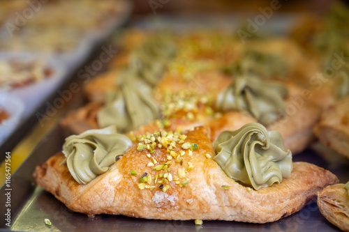 Homemade sweet pastry cannolo sfoglie filled with almond, pistachio, lemon, vanilla, chocolate cream on food market in Italy photo