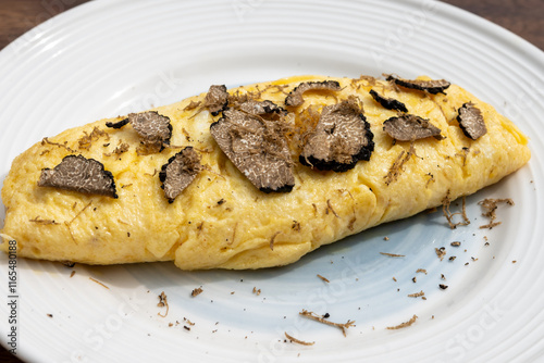 French omelette with mushrooms, fresh farmers eggs and black summer truffle mushroom in pieces for making truffle dishes with tasty aroma photo