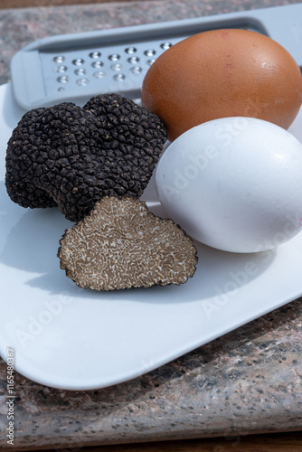 Ingredients for French omelette with mushrooms, fresh farmers eggs and black summer truffle mushroom in pieces for making truffle dishes with tasty aroma photo