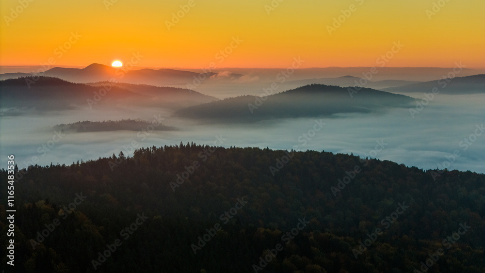 Naklejka premium Aerial drone view of sunrise above clouds in mountains