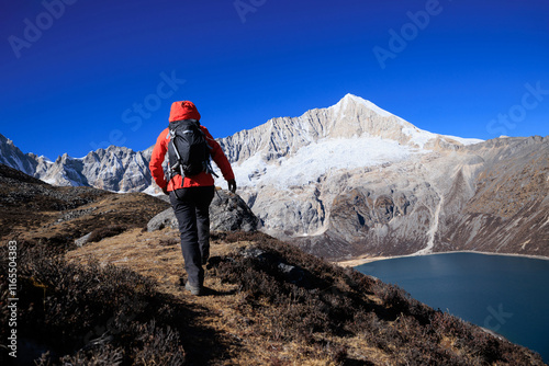 Backpacking woman hiking on high altitude mountain top photo