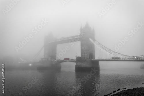 Obraz na płótnie Moody view of the Tower Bridge of London, England, during a foggy autumn day with a red double decker bus on the bridge w salonie