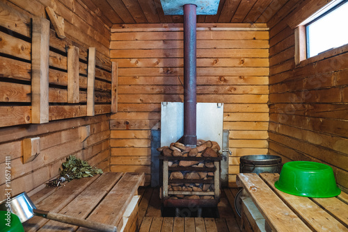 The wooden sauna features a cozy wood stove and aesthetically pleasing green bowls, creating a serene and inviting environment for relaxation and unwinding after a long day photo